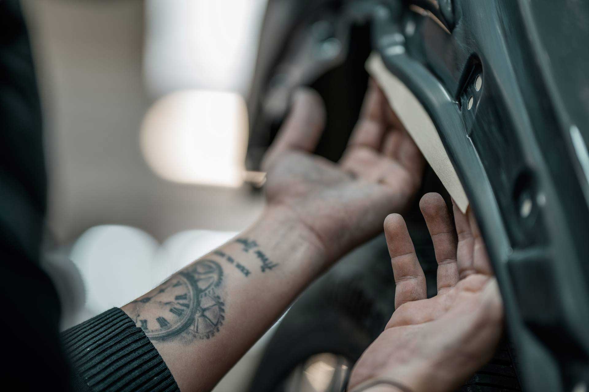 Techniker repariert Fahrzeugtür von innen bei Instandsetzung eines Autoschadens