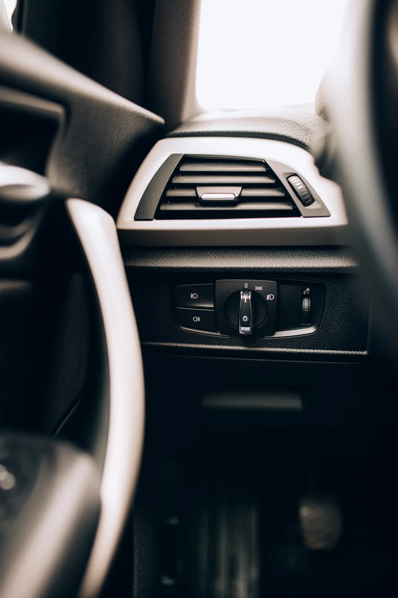 Detailaufnahme der Luftdüse und Bedienelemente der Fahrzeugklimaanlage im Innenraum