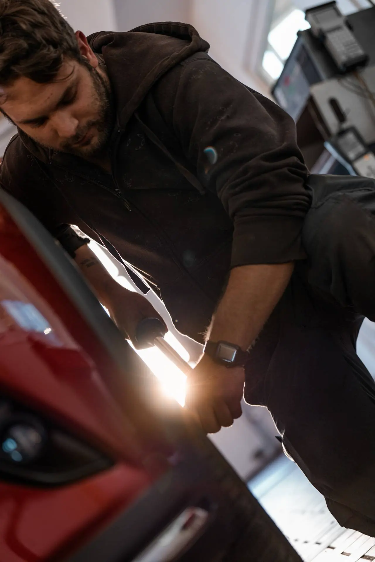 Mechaniker führt manuelle Instandsetzungsarbeiten an der Fahrzeugkarosserie durch