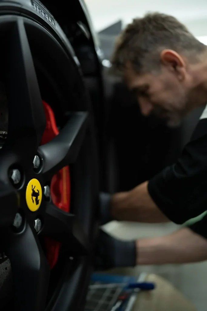 Detailaufnahme einer Ferrari-Felge mit Bremssattel während Montagearbeiten