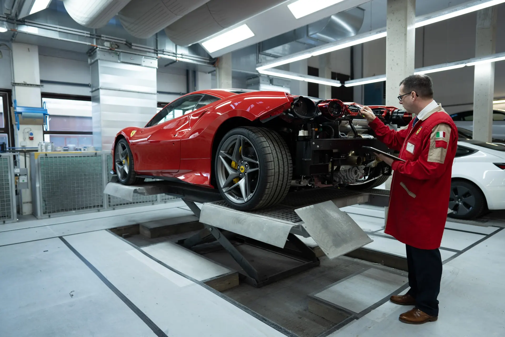 Techniker prüft einen Sportwagen auf der Hebebühne während einer Inspektion in der KFZ-Werkstatt